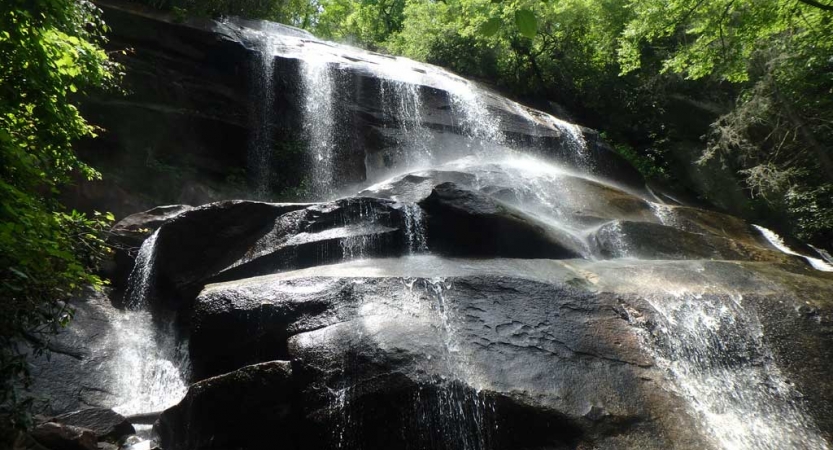 Water streams over a large rock formation